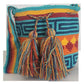 A vibrant, colorful crochet bag featuring a boho-Wayuu design. The item showcases intricate patterns typical of Bohemian and Wayuu style, with a rich mix of bright, eye-catching colors. Handmade, the bag exemplifies skilled crochet craftsmanship, ideal for adding a bohemian flair to any outfit.