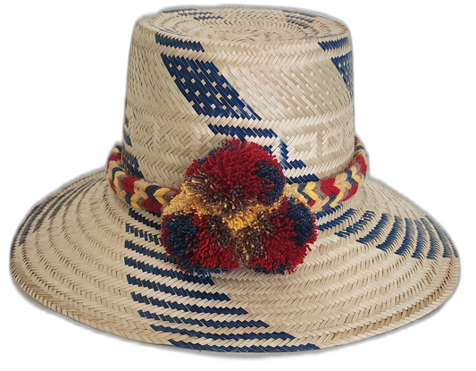 Handmade Wayuu straw hat with blue diagonal designs and vibrant pompoms