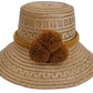 Handmade Wayuu straw hat in light natural tones with ochre pompoms.


