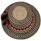 Bohemian straw hat featuring red, gold, and black pompoms and tribal design