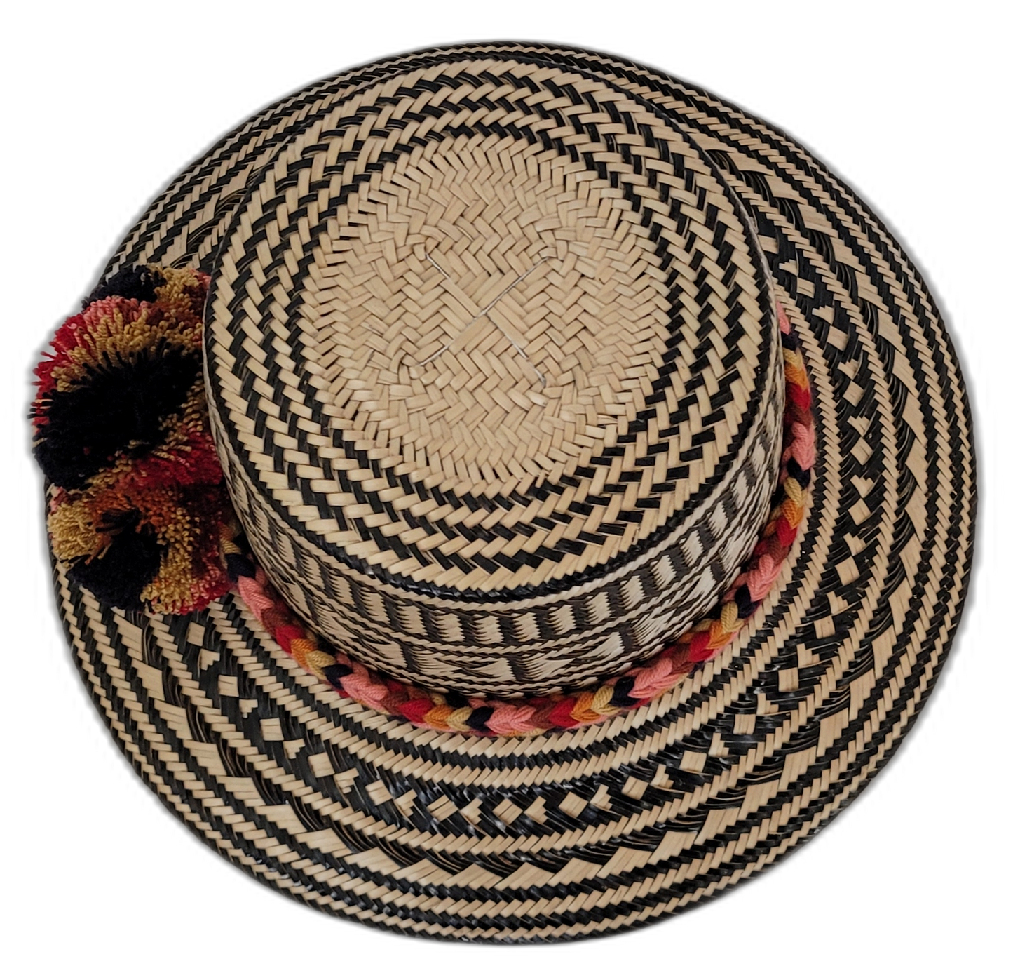 Bohemian straw hat featuring red, gold, and black pompoms and tribal design