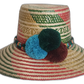 Iraca palm straw hat with traditional Wayuu patterning in festive hues and bold pompom embellishment.
