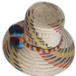 Iraca palm Wayuu hat with rich multicolor weave and handmade pompom accents symbolizing cultural meaning.