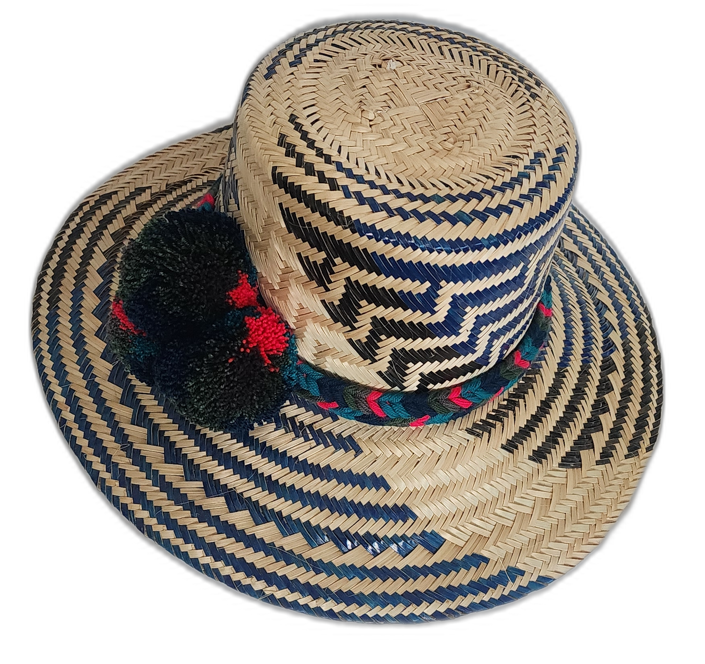 Dark-toned Wayuu straw hat with green, red, and black pompoms and braided band.
