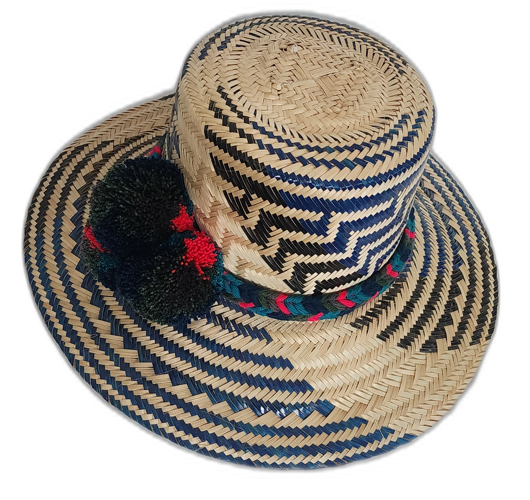 Dark-toned Wayuu straw hat with green, red, and black pompoms and braided band.