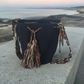 Handmade black Wayuu crochet bag with artisan multicolor tassels and a patterned strap — Boho-chic and bold.
