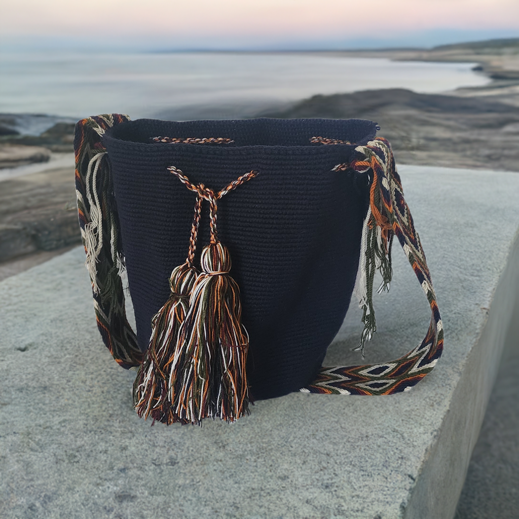 Handmade black Wayuu crochet bag with artisan multicolor tassels and a patterned strap — Boho-chic and bold.