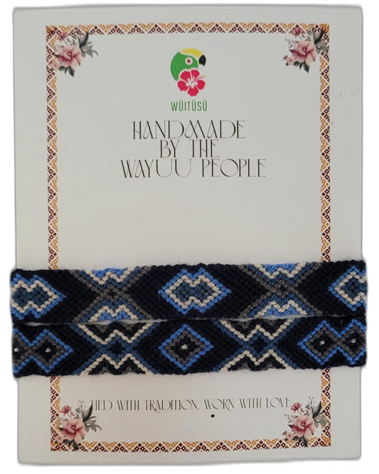 Bohemian handmade Wayuu friendship bracelet in black, brown, tan, and cream with geometric tribal patterns — a meaningful artisan accessory blending boho chic colors and ethical craftsmanship.