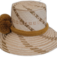 Artisan-crafted Wayuu hat, light straw with earthy gold pompoms.


