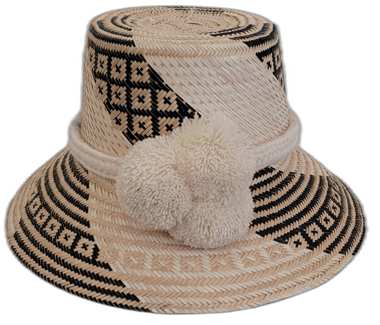 Handmade Wayuu bohemian straw hat with cream pompoms and black-beige geometric woven patterns.