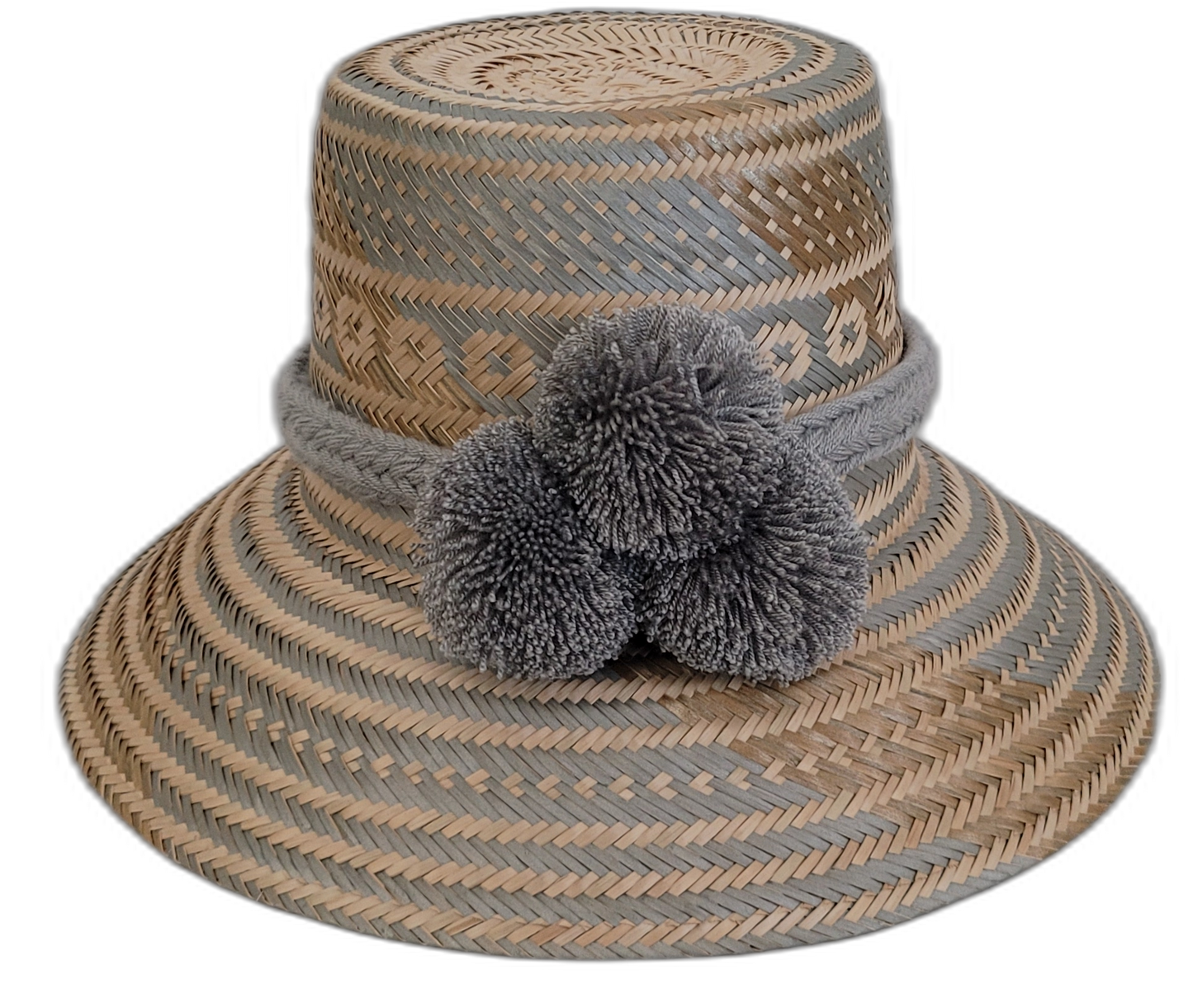 Handmade Wayuu bohemian straw hat with soft gray pompoms and beige-gray woven patterns.

