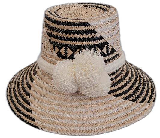 Handmade Wayuu bohemian straw hat with cream pompoms and black-beige woven patterns.

