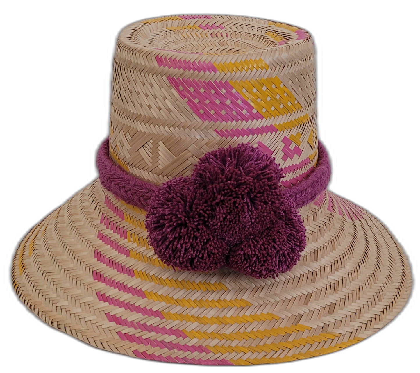 Handmade Wayuu bohemian straw hat with pink, yellow, and purple patterns and large pompoms.

