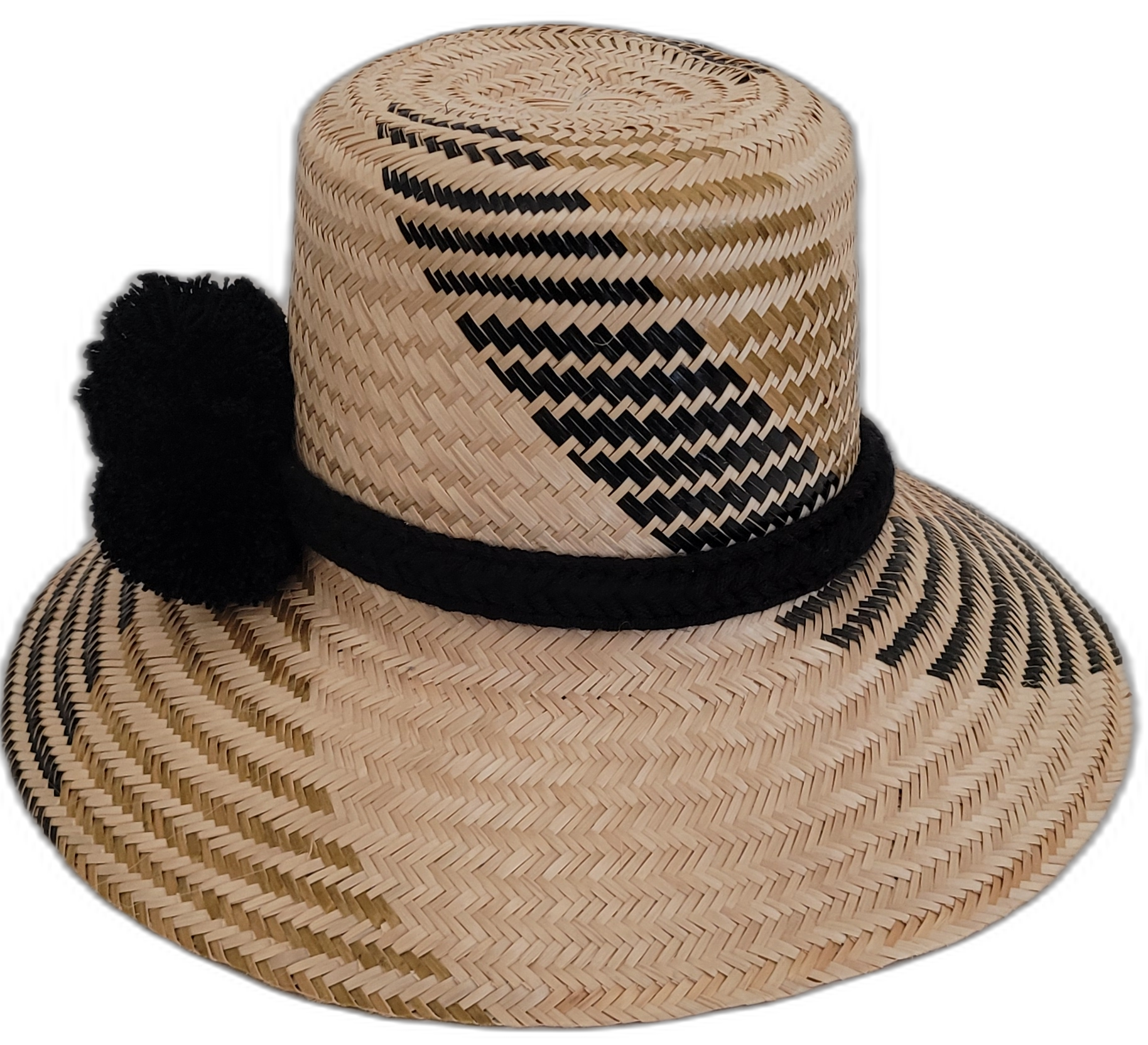 Boho-chic Wayuu straw hat featuring black pompoms and intricate design.

