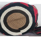 Bohemian-style crochet Wayuu mochila in earthy hues and tribal design, complete with multicolor tassels and wide strap — handmade with care.