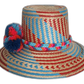 Colorful straw hat with pink, blue, and red pompoms and braided band.Boho straw hat with vibrant zigzag design and bold colorful pompoms

