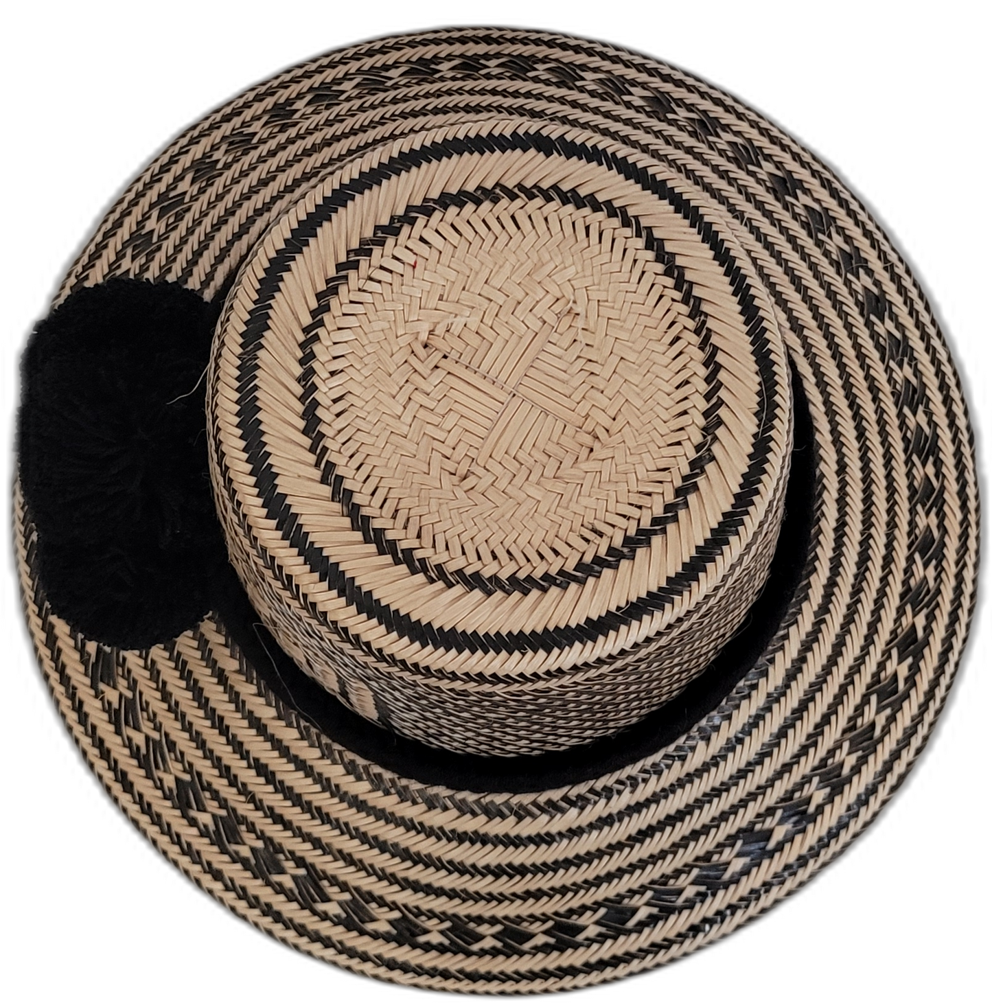Boho chic black Wayuu straw hat, featuring deep black woven patterns and pompoms.


