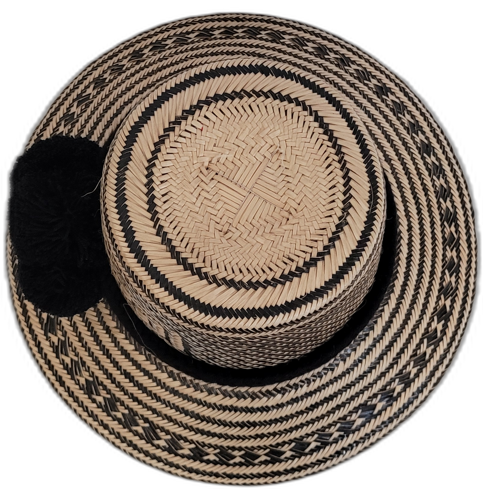 Boho chic black Wayuu straw hat, featuring deep black woven patterns and pompoms.

