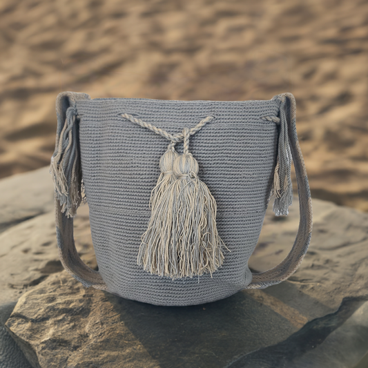 Handmade gray Wayuu crochet bag with matching artisan tassels and strap — a minimalist Boho-chic statement for everyday wear.