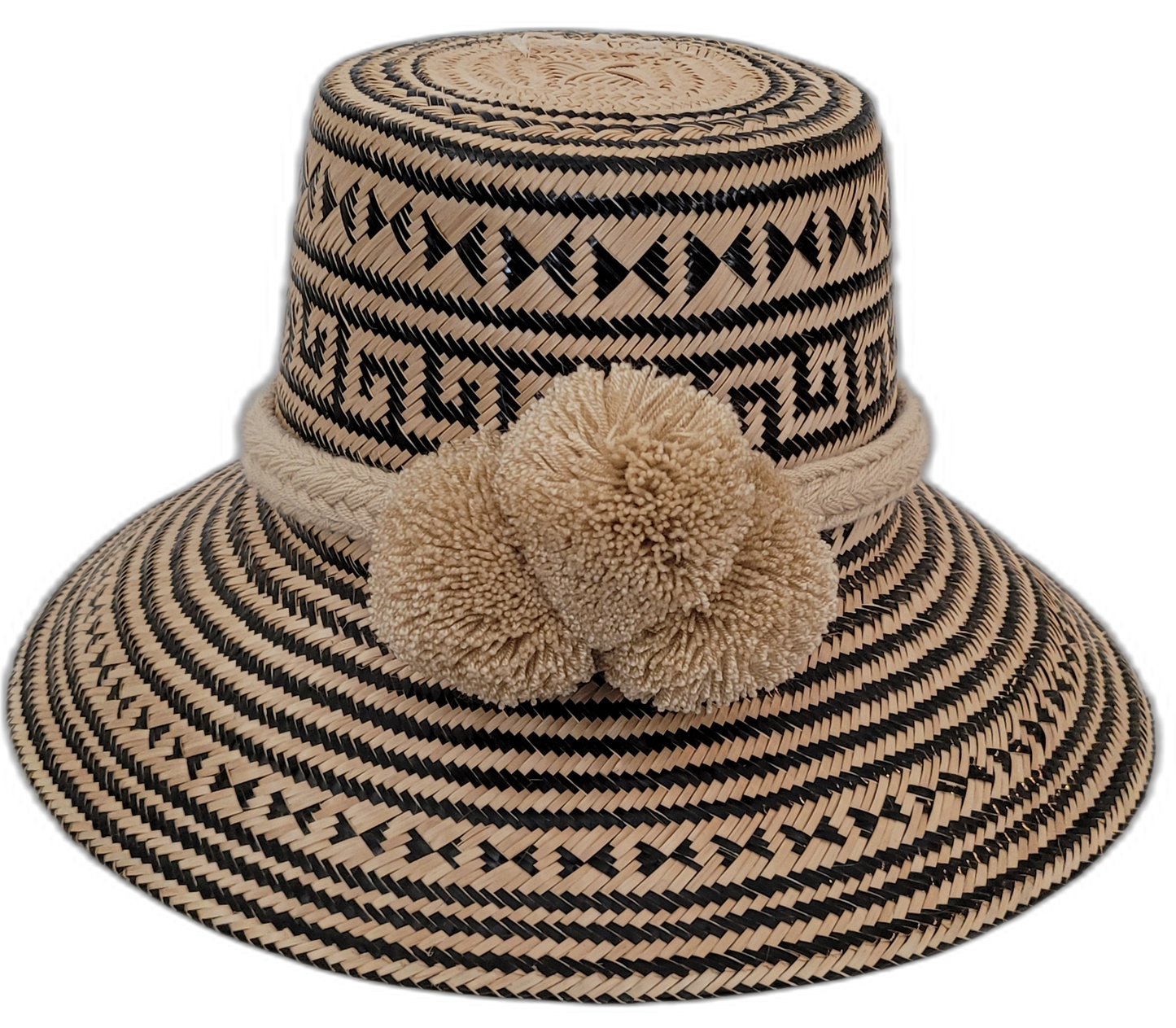 Handmade Wayuu straw hat featuring bold black and natural palm patterns with large pompoms

