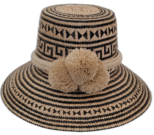 Handmade Wayuu straw hat featuring bold black and natural palm patterns with large pompoms


