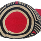 Colorful handmade Wayuu crochet bag in modern tribal pattern with vivid red accents and tassels — perfect for bold boho-chic fashion lovers.