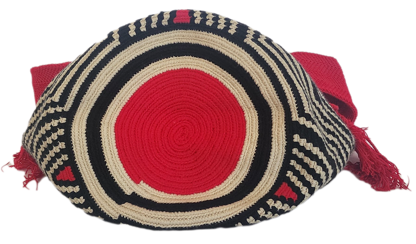 Colorful handmade Wayuu crochet bag in modern tribal pattern with vivid red accents and tassels — perfect for bold boho-chic fashion lovers.