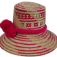 Boho straw hat handwoven by Wayuu artisans with eye-catching red pompoms.

