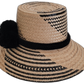 Boho straw hat with black pompoms, handwoven by Wayuu artisans.

