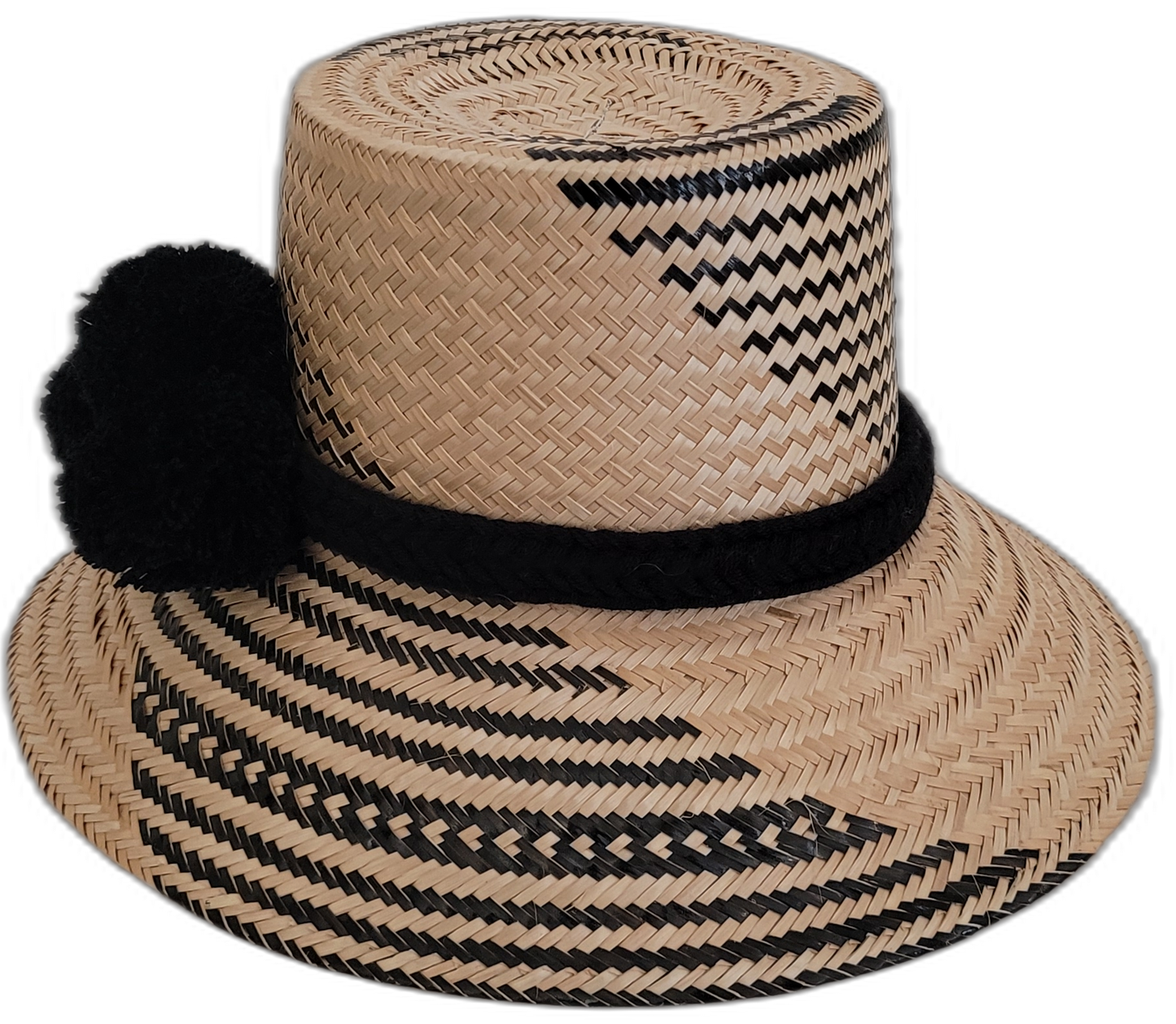 Boho straw hat with black pompoms, handwoven by Wayuu artisans.

