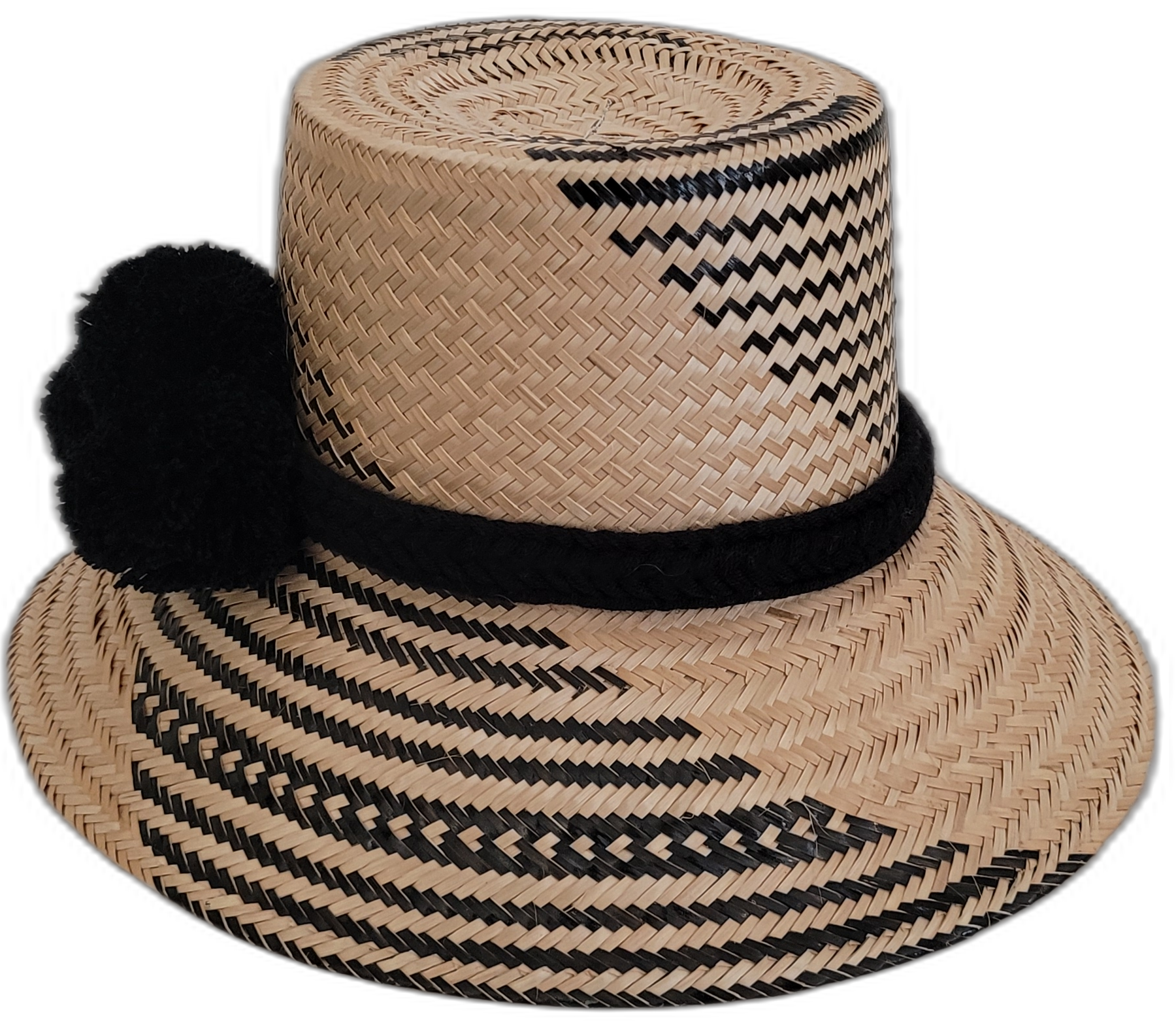 Boho straw hat with black pompoms, handwoven by Wayuu artisans.

