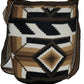 Large boho chick crochet bag in brown, cream, black tones, artisan crossbody strap, striking geometric design, and oversized tassels.
