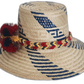 Boho straw hat featuring red, yellow, and navy pompoms woven by artisans
