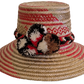 Boho chick straw hat with red and black pompoms, handmade by Wayuu artisans