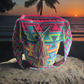 Colorful handmade Wayuu crochet bag with bold neon geometric patterns and boho-chic tassels.