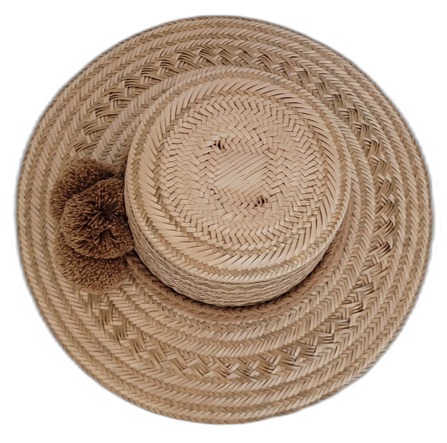 Wayuu handcrafted straw hat in natural tones with brown pompoms.


