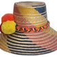 Artisan-crafted straw hat by Wayuu people, with a colorful geometric weave and vivid handmade pompoms.