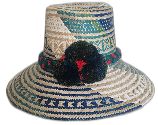 Boho straw hat handmade by Wayuu artisans, featuring blue and green woven designs with red-accented pompoms.