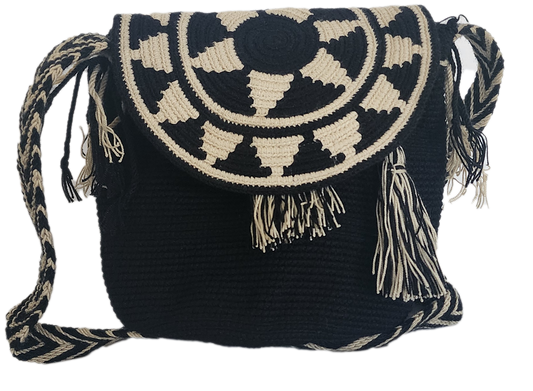Handmade Wayuu crochet flap bag in black and beige with geometric tribal sunburst design and tassels — a bold artisan boho-chic essential.