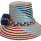 Natural straw Boho hat with burgundy, blue, and yellow pompom and band.Boho straw hat with diagonal artisan design and braided crown band


