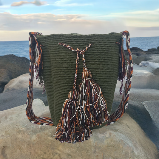 Boho-chic handmade Wayuu crochet bag in olive green with multicolor tassels and a patterned artisan strap — vibrant, earthy, and stylish.