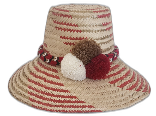 Handmade Wayuu straw hat in red and natural with white, brown, and red pompoms.Artisan boho hat with a diagonal red pattern and burgundy pompom trio

