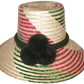 "Colorful artisan Wayuu hat with decorative pompoms, handwoven from Iraca palm, showcasing unique craftsmanship and cultural 