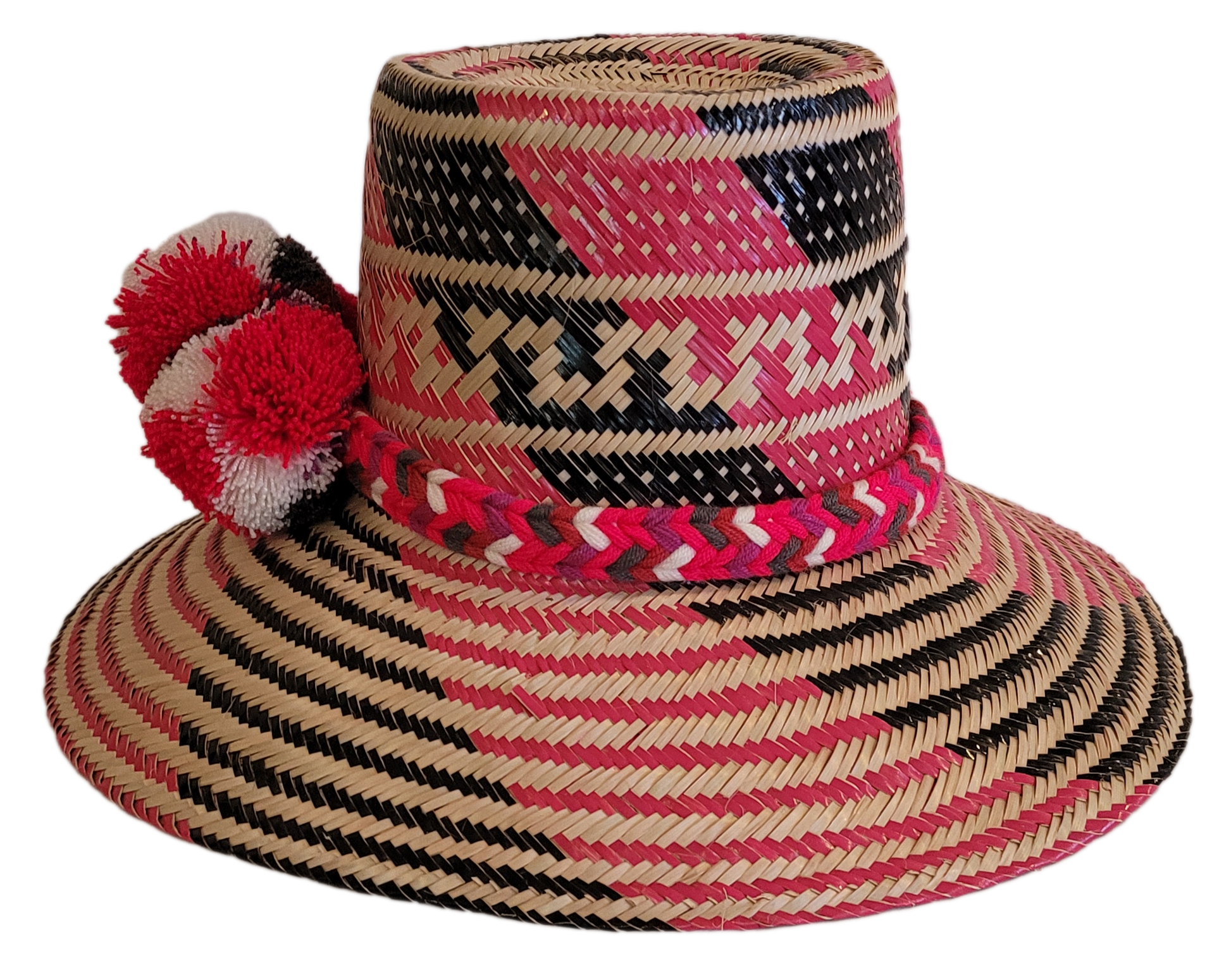 Boho straw hat featuring a vivid pink weave and bold red pompom cluster.