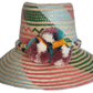 Handmade boho straw hat with vibrant pastel stripes and multicolor pompoms, crafted by Wayuu artisans.
