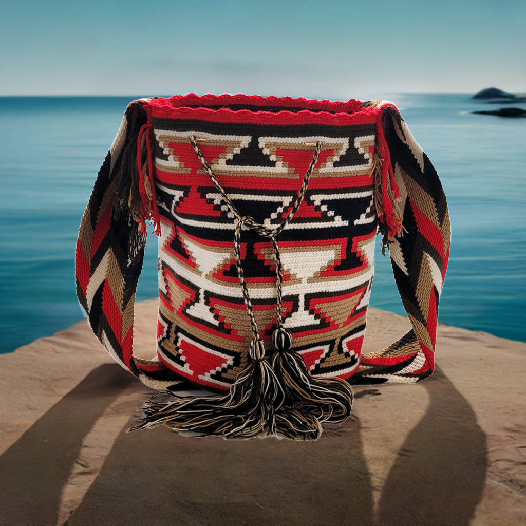 Colorful Wayuu mochila bag in red, beige, black, and cream tones. Ethically made from vegan acrylic yarns with striking cultural motifs