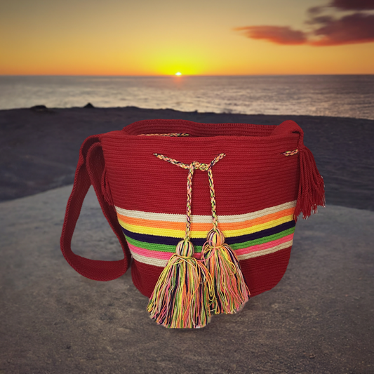 "Colorful handmade crochet bag by Wayuu artisans featuring vibrant patterns and earthy tones, perfect for a boho-chic look."
