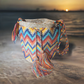 "Colorful handmade crochet crossbody bag by Wuitusu, showcasing intricate Wayuu patterns, with a flexible, long strap."