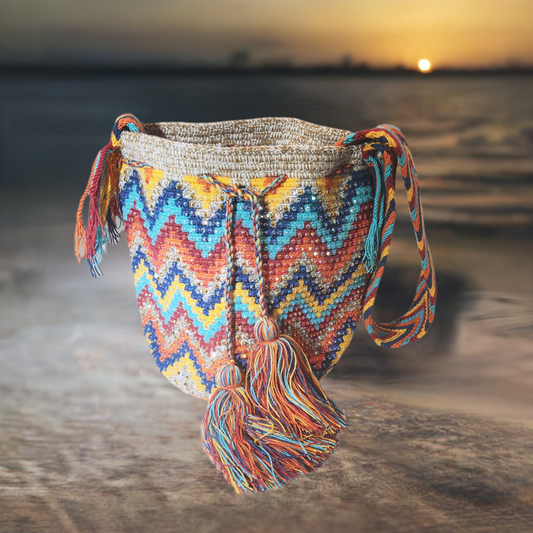 "Colorful handmade crochet crossbody bag by Wuitusu, showcasing intricate Wayuu patterns, with a flexible, long strap."