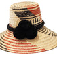 "Colorful handmade hats by Wuitusu, crafted from Iraca palm fibers by the Wayuu tribe, adorned with cultural pompoms."